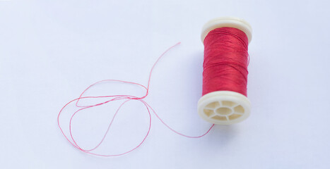 Spool of red thread on white background. Fashion. 