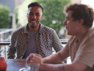 UK, South Yorkshire, Smiling gay couple at restaurant table