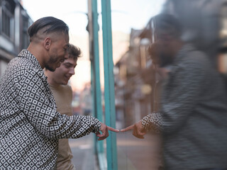 UK, South Yorkshire, Smiling gay couple looking at store window