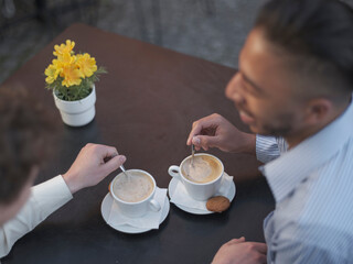 UK, South Yorkshire, Close-up of gay couple enjoying coffee at cafe table