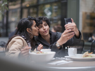 Female couple taking selfie in restaurant