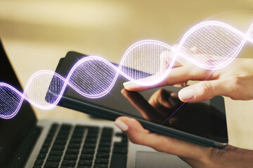 Creative concept with DNA symbol illustration and finger clicks on a digital tablet on background....