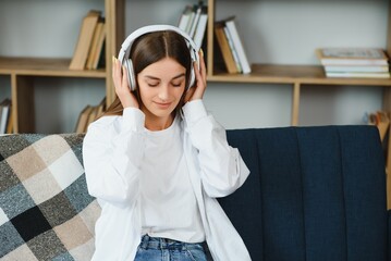 Girl with a laptop and headphones listens to music.