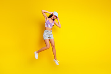 Full length photo of cute dreamy girl dressed swimsuit bra cap jumping up empty space isolated yellow color background