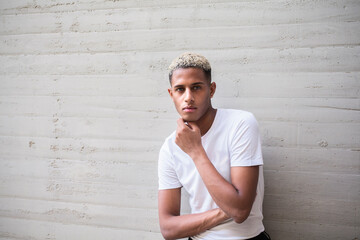 Black man standing near wall on street