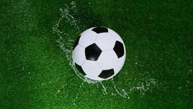 Close-up of Falling Soccer Ball on Football Field, Rainy Weather. Super Slow Motion at 1000 fps. Filmed on High Speed Cinematic Camera.