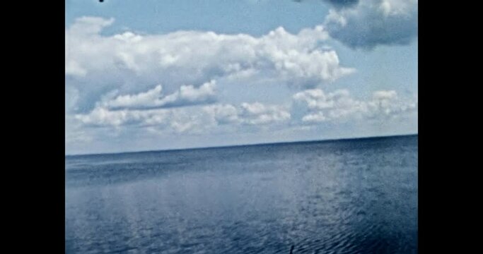 Blue sea with cloudy horizon in summer. Beautiful seascape of blue boundless sea, sunny day. Amateur ocean nature video. Coast line archival footage. Vintage color film. Family archive. Retro 1980s 