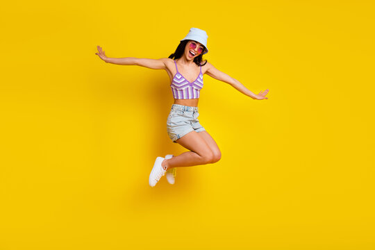 Full size picture of jumping girl in knitted bralette spend summer vacation on beach isolated on yellow color background