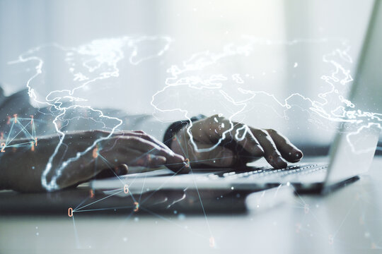 Double exposure of abstract digital world map and hand typing on laptop on background, big data and blockchain concept