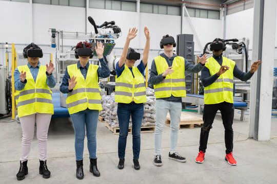 AI and machine learning can improve productivity in the manufacturing industry. multiracial engineers robotic arm operator. They are using VR glasses to simulate real production.