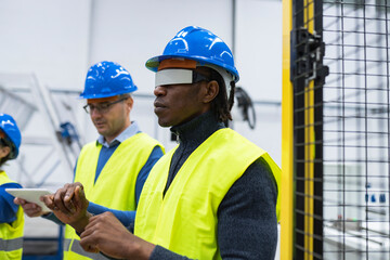 Engineers manufacture robotics use virtual reality system software - Focus on african man -