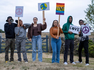 Group of teenagers (16-17) holding peace banners