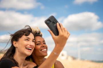 Female couple taking selfie on beach