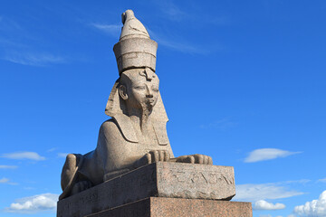 Sphinx at Universitetskaya Embankment against blue sky with clouds . Saint Petersburg Sphinxes are...