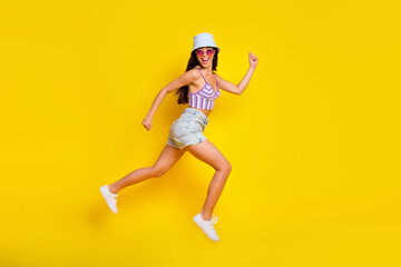 Full length profile side photo of energetic female running on beach enjoy summer holidays isolated on yellow color background