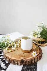 Obraz na płótnie Canvas Cup of chamomile tea on a wooden tray