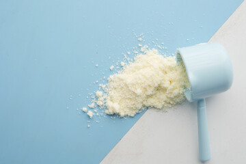 Close up of baby milk powder and spoon on tile background.