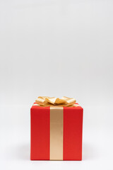 Close-up one red paper gift box golden bow ribbon