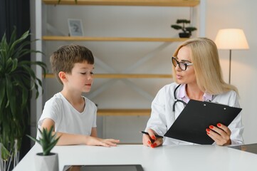 Obraz premium Healthcare for children: Little boy talking to doctor during visit to hospital.