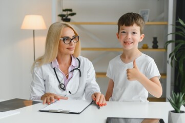 Happy child next to a doctor in hospital ward