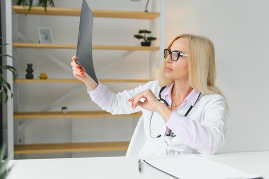Shot of female doctor holding an x-ray image and analyzing.