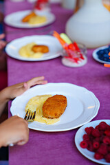 plate. the child eats mashed potatoes and cutlets. 