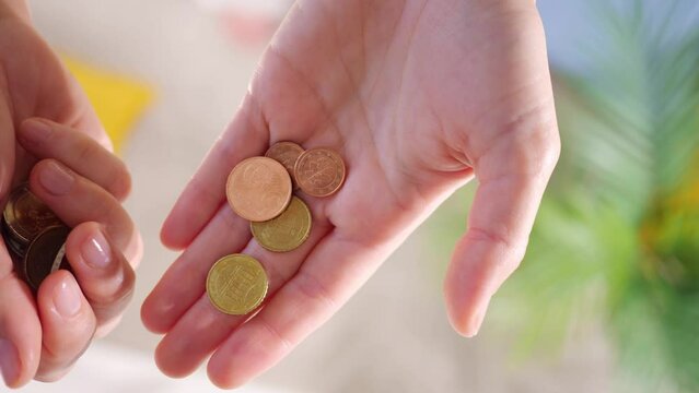 Hands hold euro coins of different denominations. State aid in times of crisis to compensate for inflation. Salary increase and basic social security. Inflation, purchasing power and social crisis.