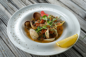 Cooked Clams vongole in a plate. Seasoned with tomatoes and spices.