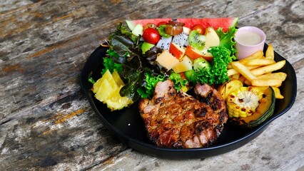 Grilled steaks pork with  mixed fruit  and green salad.