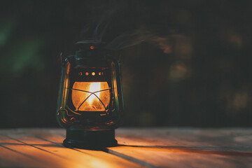 antique kerosene lamp with lights on the wooden floor at night © Pongvit