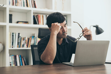 Fototapeta sad depression serious people from work,study stress problem.asian man feeling tired suffering using computer working work place.concept global economic,health problems obraz