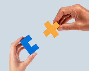 Man and woman hands joining two puzzle pieces. Partnership, connection concept. Mutual...