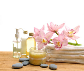 Obraz na płótnie Canvas Spa setting with bottles of essential oil , towel, orchid ,stones on wooden background