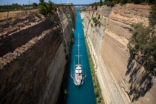 Boat in the canal of Corinth. A sailboat crosses the Corinth Canal in the Peloponnese. Greece, July 2022.