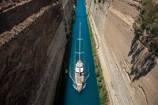 Boat in the canal of Corinth. A sailboat crosses the Corinth Canal in the Peloponnese. Greece, July 2022.