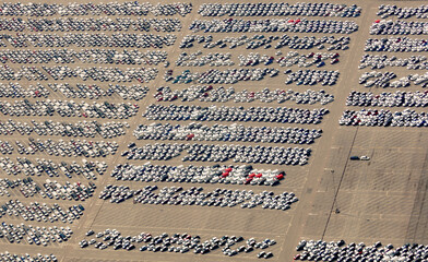 Several hundred cars and trucks parked in a sprawling parking lot.  - 520801027