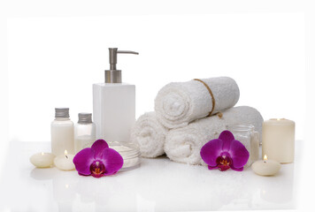 Fototapeta na wymiar Skin care SPA concept with orchid and rolled towel, oil bottle, candle on white background 
