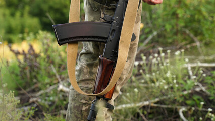 a Ukrainian soldier in camouflage holds a machine gun in a combat position. an infantryman at a...