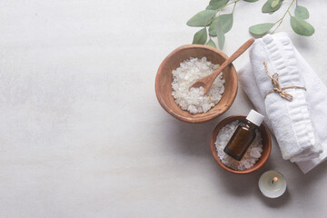 Set of green eucalyptus and leaves with ,oil bottle spoon salt in wooden bowl ,spa ball ,rolled towel  border