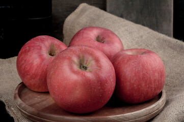 Close-up of apples on wooden tray with burlap base