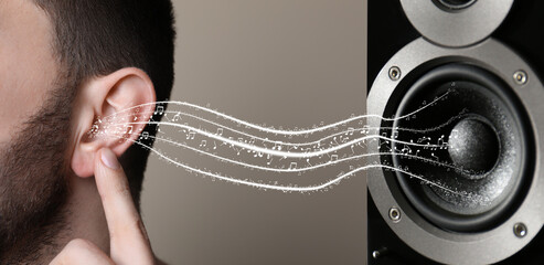Modern audio speaker and man listening to music on light grey background, closeup view of ear....