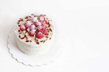 Raspberry white mastic cake decorated fresh berries on cake stand, white table.
