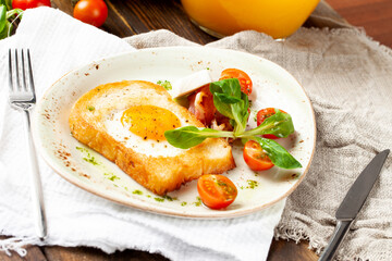 Fototapeta na wymiar Fried egg in a piece of bread in a plate