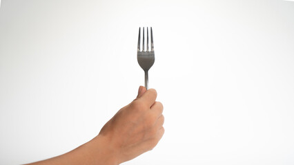 The hand holds the fork with its teeth up on a white background