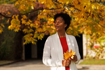 Beautiful African-American woman walking in an autumn garden
