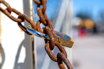 Rusty chains selective focus. Rusty thick chains locked with big metal lock.