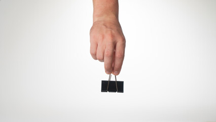 A man's hand on top holds a clip to clip paper space for text