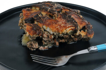 Assiette de moussaka avec une fourchette en gros plan