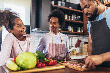 Happy multigenerational african american family make dinner together.