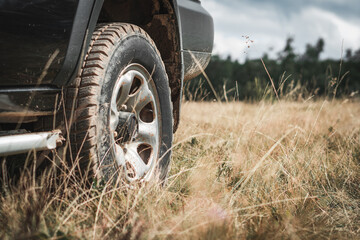 A black offroad all terrain vehicle on a green pasture in the mountains